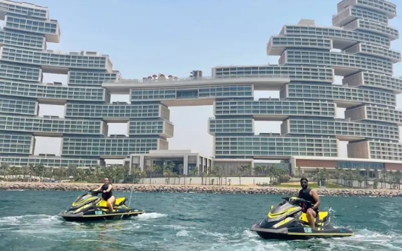 Riders on yellow jet skis approaching the Royal Atlantis at the Palm Jumeirah in Dubai